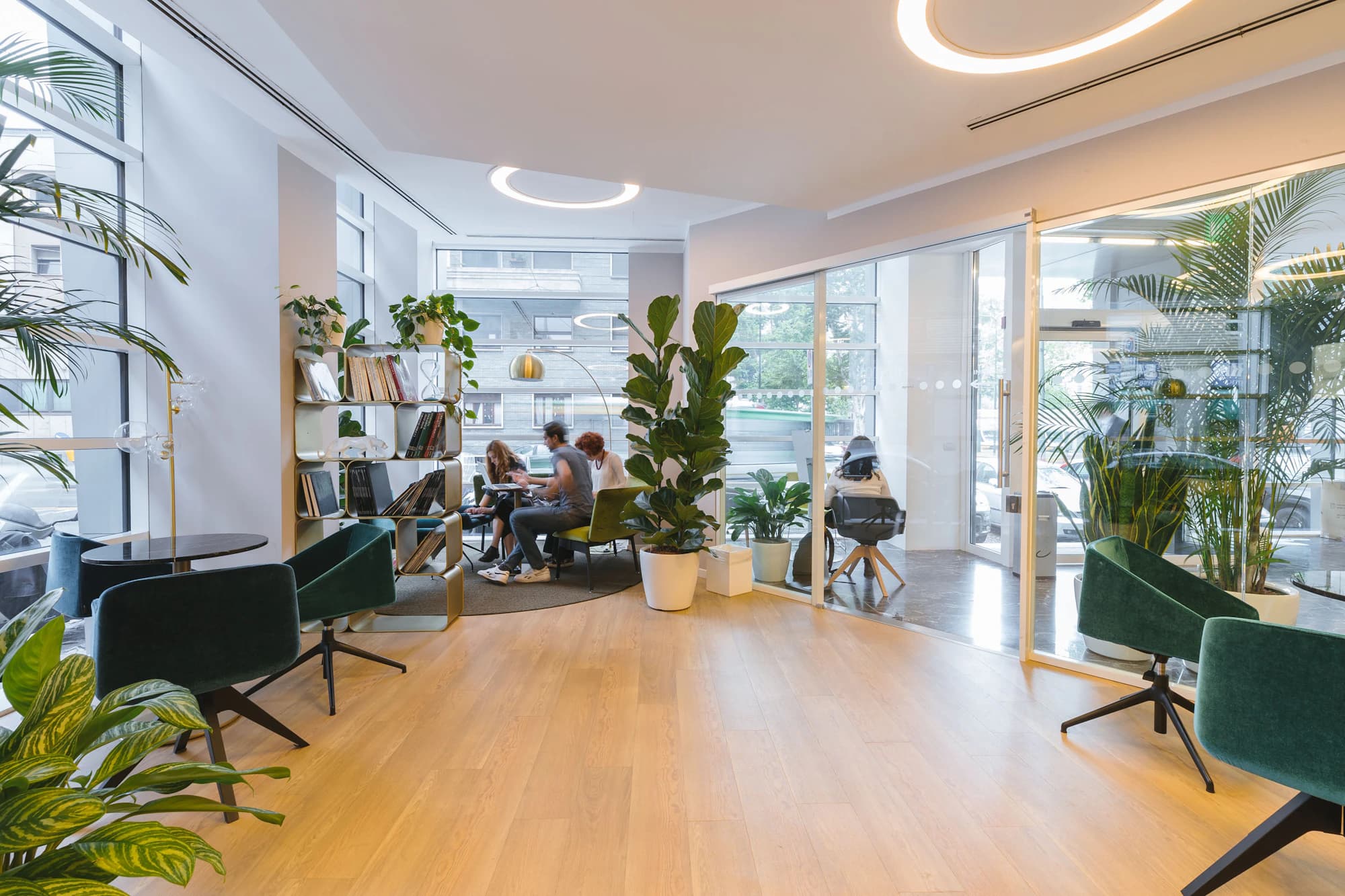 Bright workspace with lounge chairs, plants and floor-to-ceiling windows